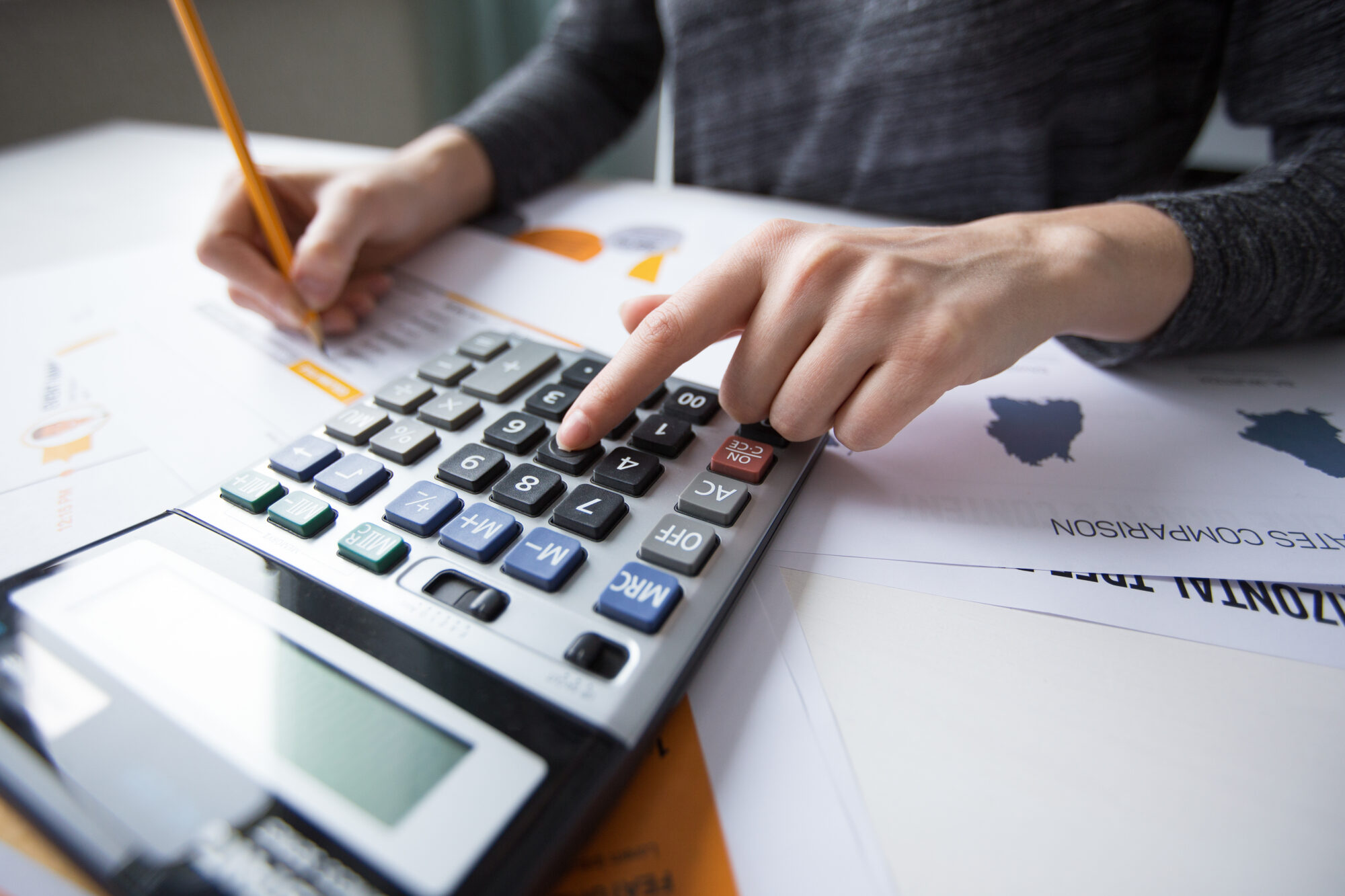 Close Up Of Female Hand Counting With Calculator
